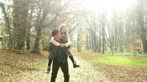 Father carrying his daughter on back at park Stock Footage 59553647