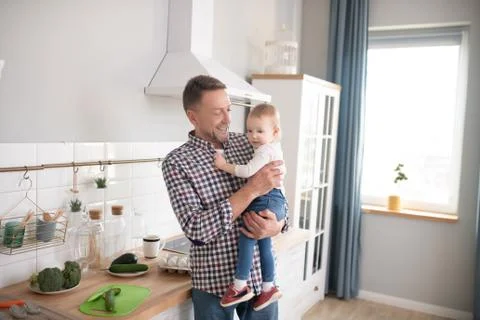 Father in a checkered shirt looking hapy with his cute baby daughter Stock Photos