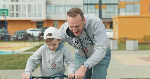 A father cheering up son on his first bicycle ride Video stock 122429682
