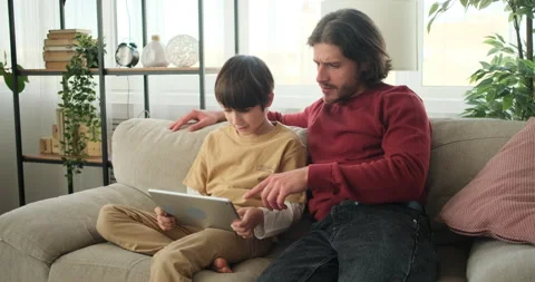 Father cheering for son playing on digital tablet Stock Footage 145231949