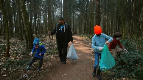 Father with children collects solid garbage in a city park. COVID 19 Stock Footage 128164283