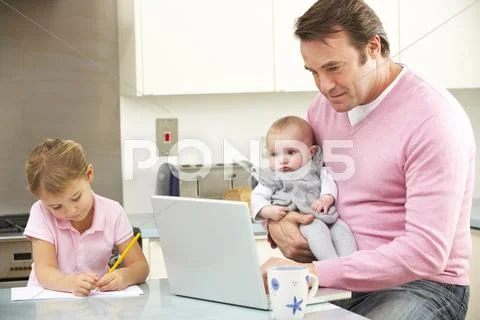 Father with children using laptop in kitchen Stock Photos