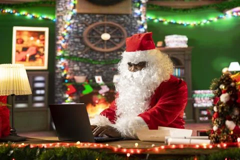 Father Christmas is navigating the web checking on children wish lists Stock Photos