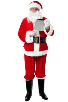Father Christmas using new tablet device Stock Photos
