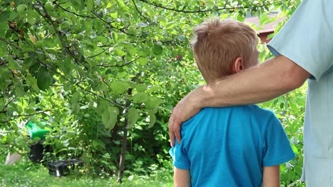 Father comforts his distressed son by placing hand on his shoulder. Stock Footage 247007946