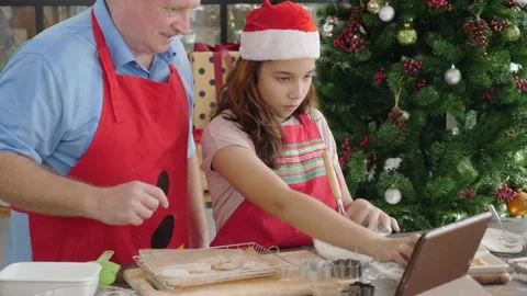 Father &amp; Daughter using tablet, touching screen while making christmas cookie Stock Footage 140076542