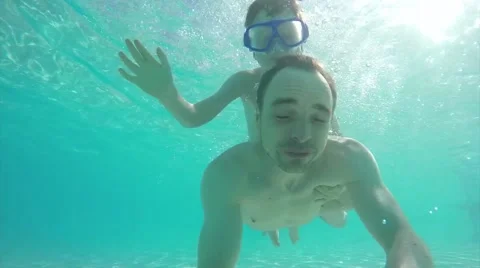 Father diving underwater with son on his back selfie Stock Footage 50237591