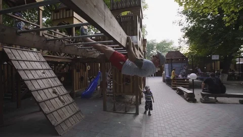 Father doing exercises on the playground Stock Footage 94346646