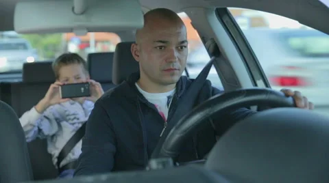 Father driving while the son is taking pictures of him Stock Footage 45520770