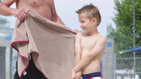 Father drying off son by the pool Stock-Footage 80134285