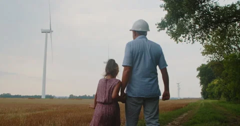 Father is an engineer with a doer in a field with felt turbines. Vídeo Stock 209563017