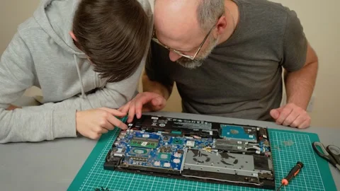Father explaining components for son, pointing at motherboard and discussing Video stock 303281466