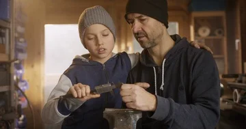 A father explains his son tools in a workshop Stock Footage 85811441