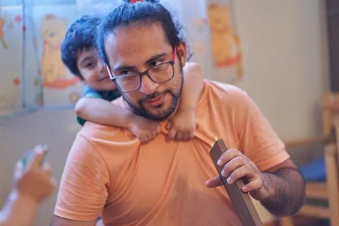 Father fed up with son's game. Assembling furniture at home. Carpentry sessio Stock Photos