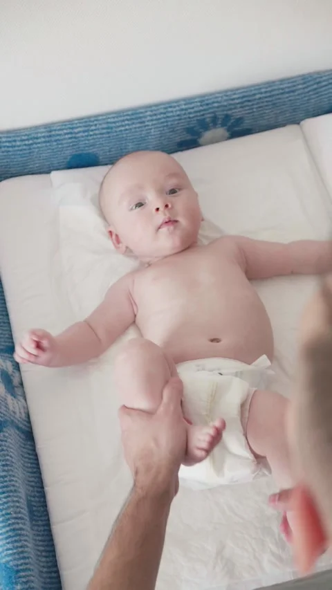 Father gently performs newborn gymnastics with her tiny baby boy. Stock Footage 315581464