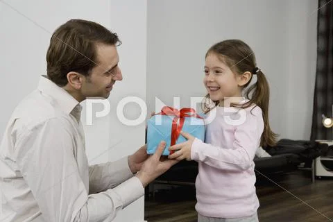 A father giving his daughter a present Stock Photos
