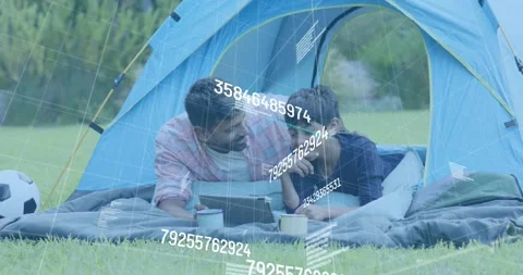 Father guiding son toward device in tent, son pressing button showing charts for Stock Footage 318010035