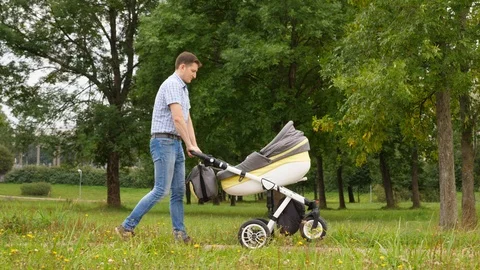 The father is having fun and playing with a stroller Stock Footage 95690833