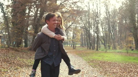 Father having fun with daughter, carrying her on his back at park Stock Footage 59553650