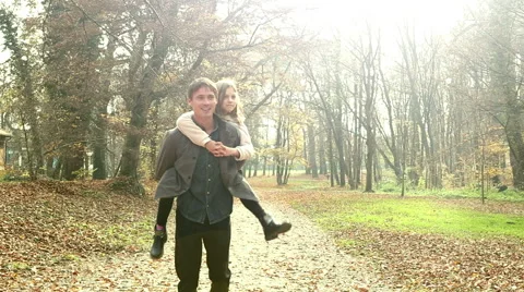 Father having fun with daughter, carrying her on his back at park Stock Footage 59553666