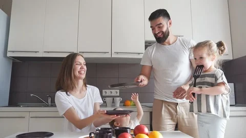 Father having fun with pancakes in the kitchen Stock Footage 117897904