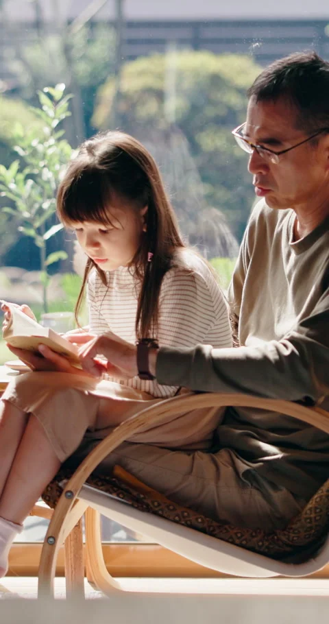 Father, help and reading book in home with Asian child, knowledge and learn for Stock Footage 341094970