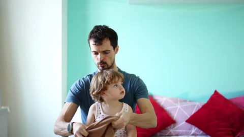 Father helping his young son get dressed Video stock 329405191