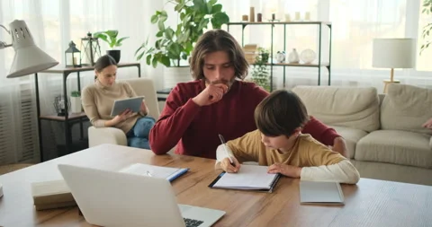 Father helping son doing homework on desk and mother using digital tablet Stock Footage 145231397