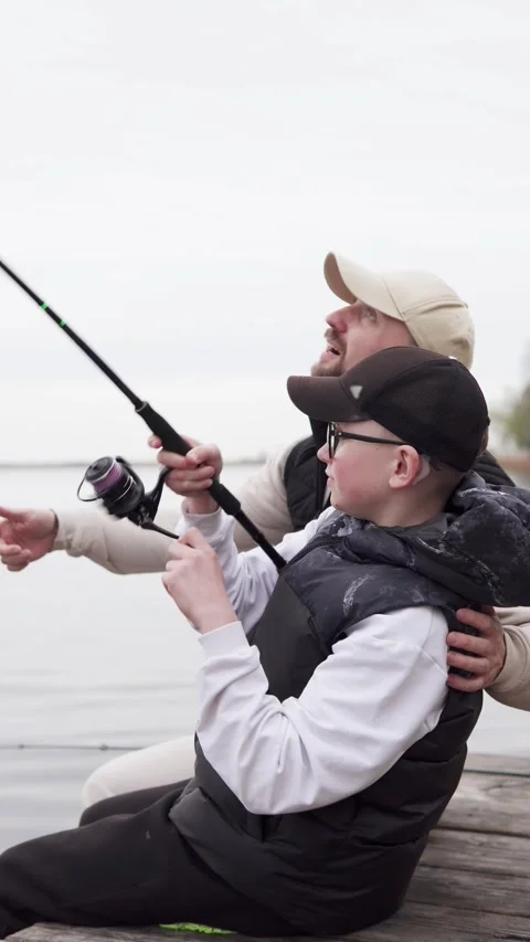 Father helping son to pull out big fish on fishing. Fatherhood concept. Stock Footage 310118807