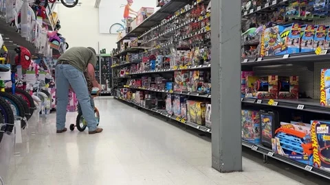 Father Helping Young Son Choose Bicycle at Walmart Store 動画素材 340582252