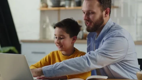 Father helps son with homework. Dad helping kid with online classes at home Stock Footage 239059302
