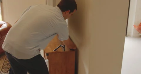 Father hiding an Easter egg begind a high tech television in the living Stock Footage 201021665