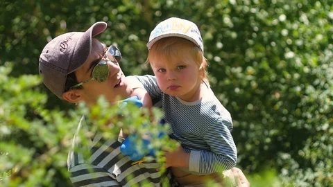 Father with his son in his arms walk outdoors. Dad and son in the mountains Vídeo Stock 106102053