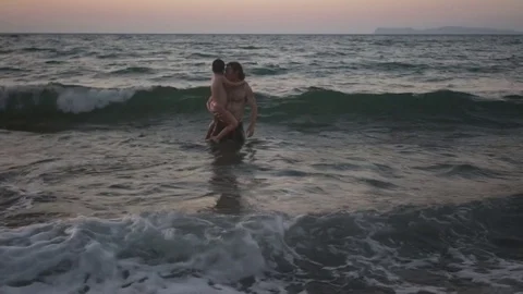 Father holding his son while swimming in the sea the evening on sunset Stock Footage 71061801