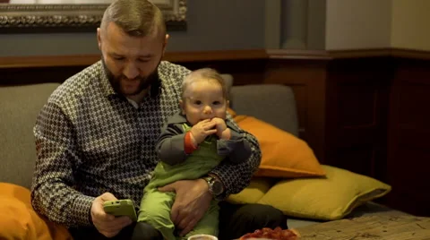 Father holding son and using phone  Stock Footage 60662701