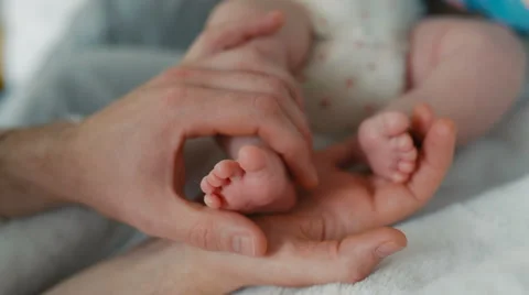 Father Holds his Tiny Baby's Toes In His Hand 動画素材 66448536