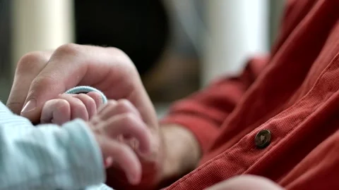 Father Holds Tiny Baby's Hands - Close Up Slow Motion Stock Footage 309650922
