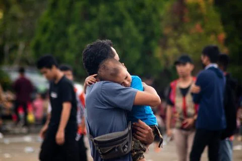Father hugging his son in the crowd Stock Photos