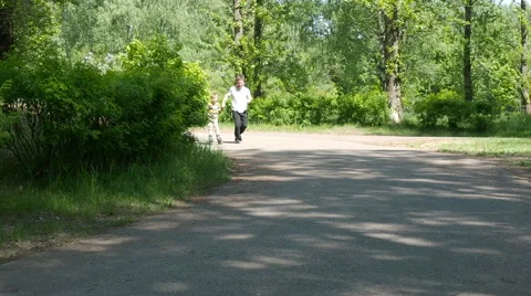 Father learning his son to ride on roller skates Stock Footage 63418446