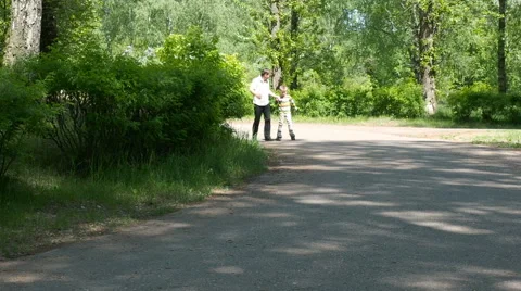 Father learning his son to ride on roller skates Stock Footage 63419502