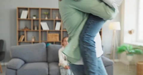 Father lifting child in arms while playing at home, joyful family moments Stock Footage 340752234
