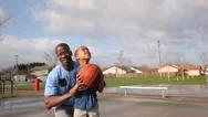 Father Lifting Son Up To Shoot Basketball Stock Footage