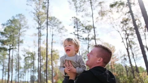 A father lifts his smiling child high in the middle of beautiful nature Stock-Footage 307152353