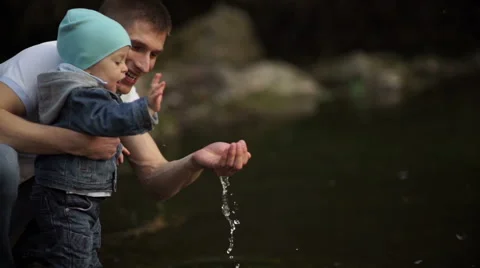 Father with little son playing on the river bank with water 2 Video stock 55116426
