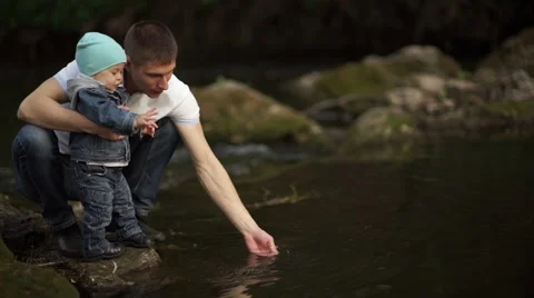 Father with little son playing on the river bank with water 3 Stock-Footage 55116477