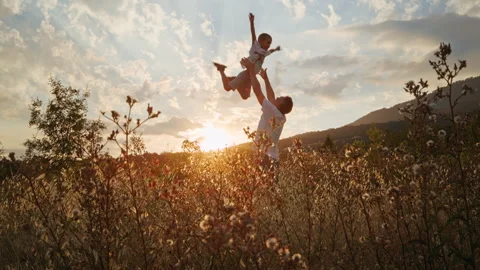 A father lovingly lifts his five-year-old son into the air with his hands. Stock Footage 245844740