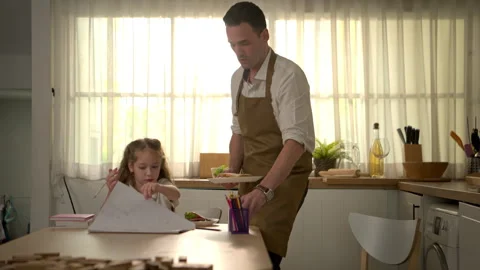 The father lovingly prepared dinner, watching over his daughter Vídeo Stock 340939387