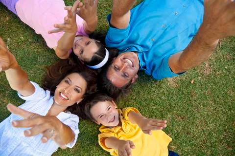 Father mother son and daughter family laying down hands up Stock Photos