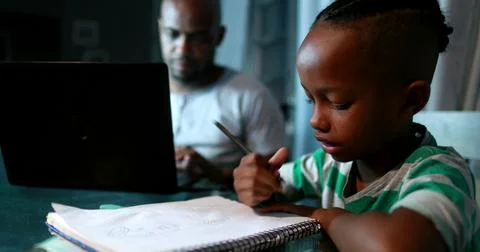 Father multi-tasking using computer laptop at home. Candid authentic and real Foto stock