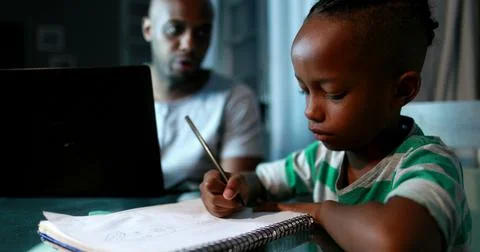 Father multi-tasking using computer laptop at home. Candid authentic and real Stock Photos